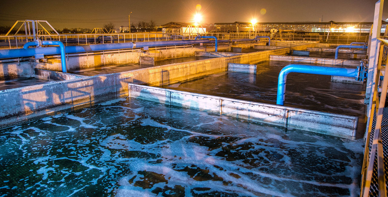 1053511 Modern wastewater treatment plant of chemical factory at night. Water purification tanks